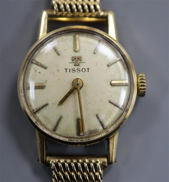 A 750 yellow metal Tissot manual wind wrist watch, on a 585 yellow metal bracelet.